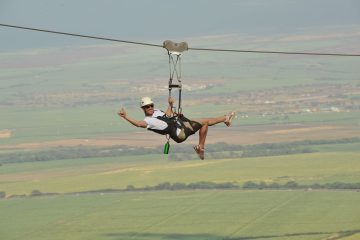 a man flying through the air on a swing